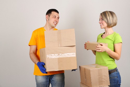 Professional movers carrying household items down stairs