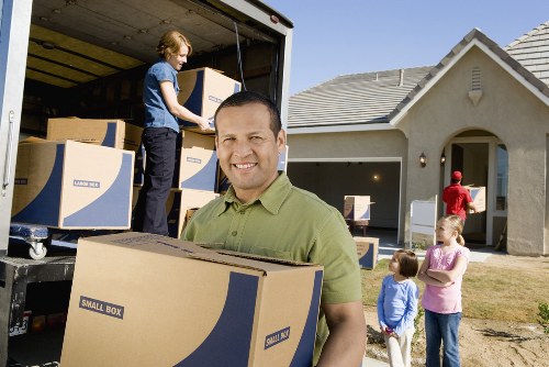 Packed moving boxes and furniture prepared for transport in Kew
